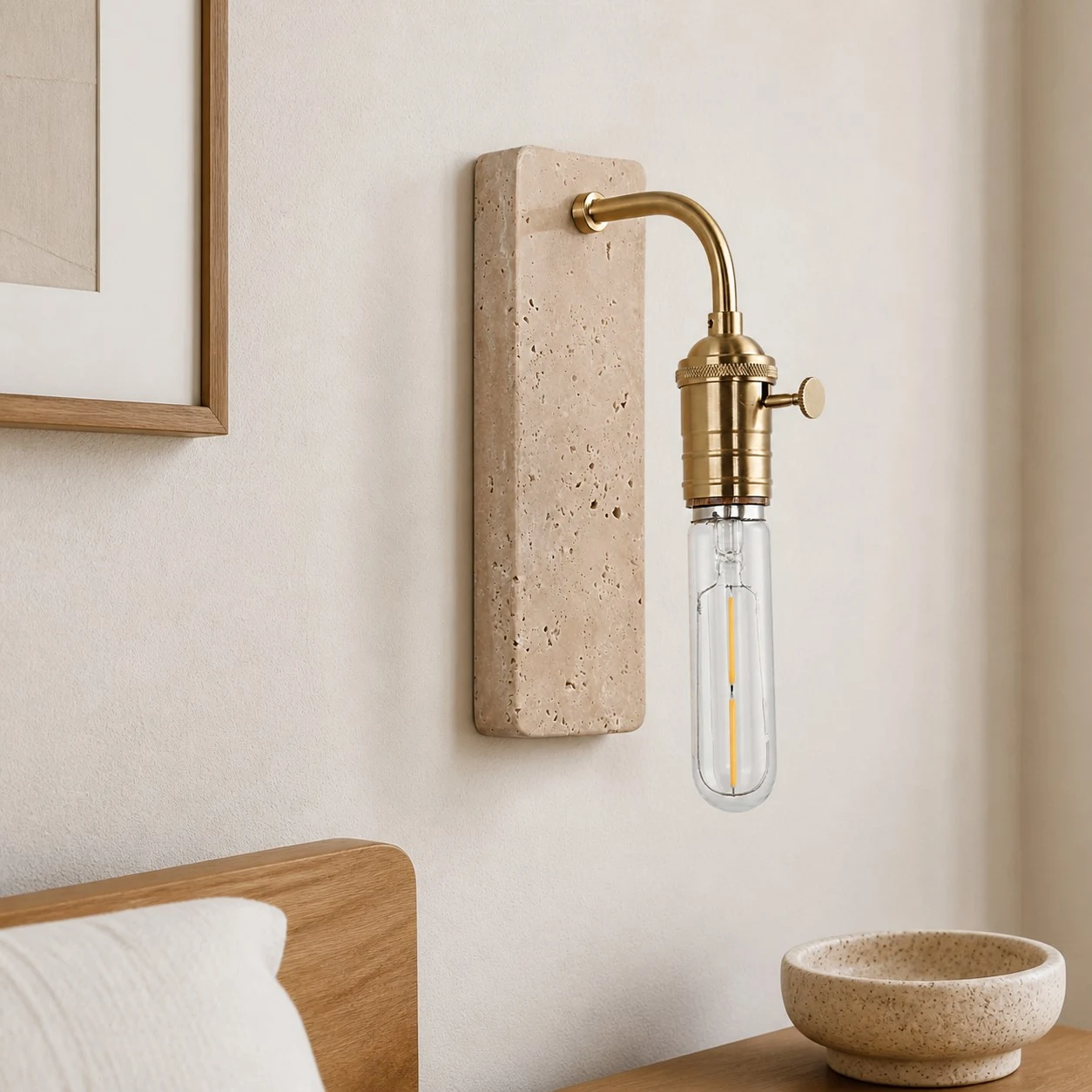 Gold travertine wall sconce installed beside a bed